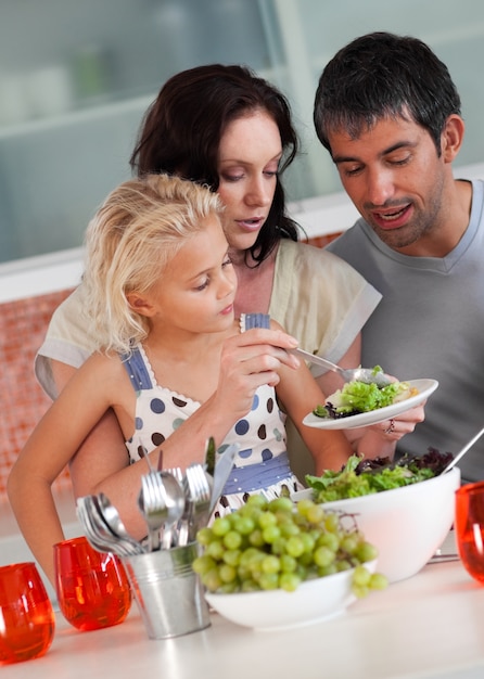 Foto ragazza carina con i suoi genitori in cucina