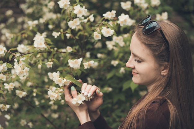 Ragazza carina con fiori di gelsomino, primavera. bellezza naturale. ecologico. ritratto