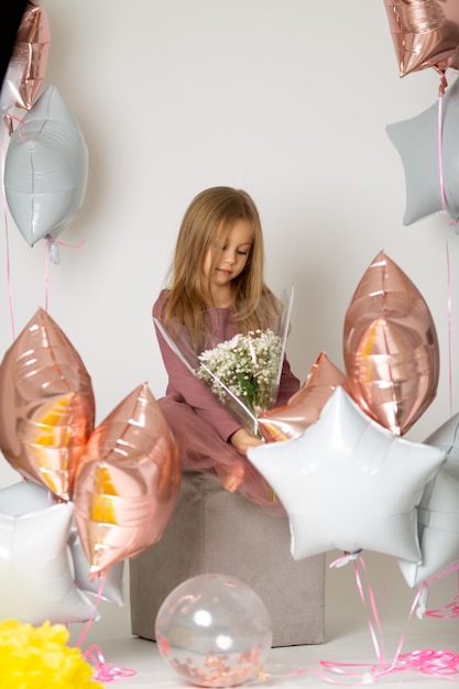 Cute girl with long hair holding a bouquet of white flowers