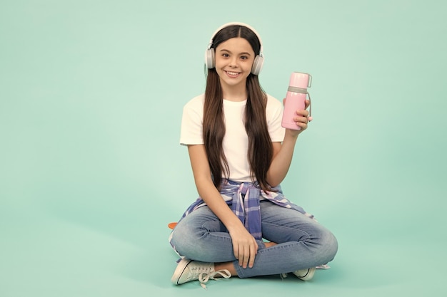 Cute girl with thermos Happy teenager positive and smiling emotions of teen girl