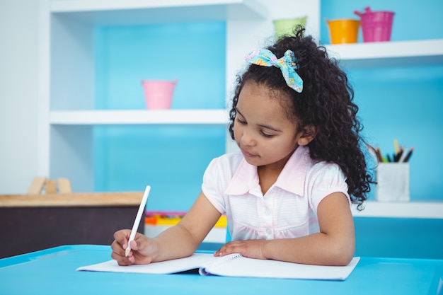 Cute girl writing on notebook