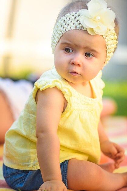 Cute girl in yellow baby clothing at back yard