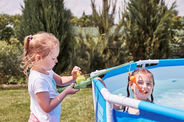 Cute girls playing by wading pool outdoors