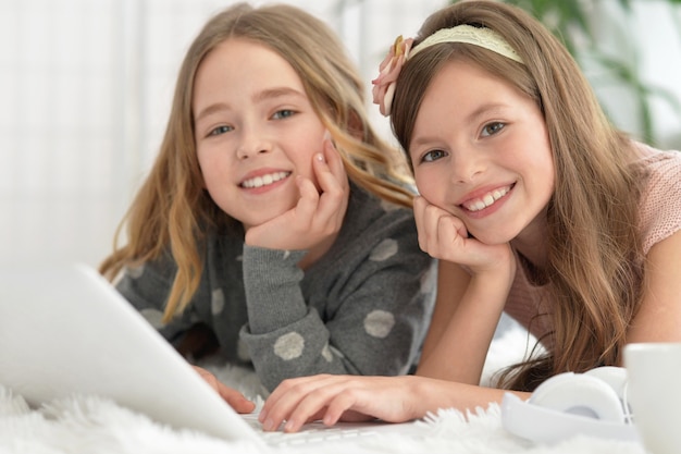 Ragazze carine con il laptop a casa