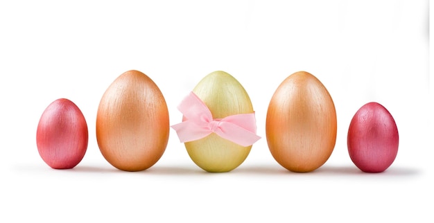 Cute golden and pink metallic Easter eggs with bow in a row isolated on white background Design element for greeting cards poster or banner