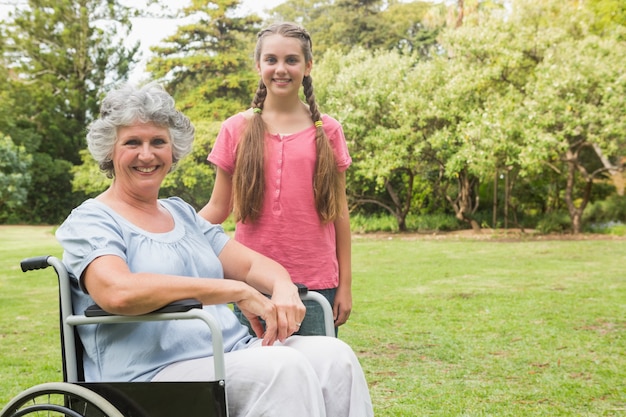 Симпатичная внучка с бабушкой в ​​инвалидной коляске