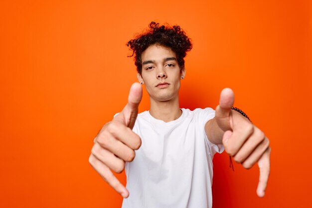 Foto ragazzo carino capelli ricci emozioni grimace studio sfondo arancione foto di alta qualità