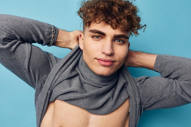 Cute guy with curly hair posing blue background