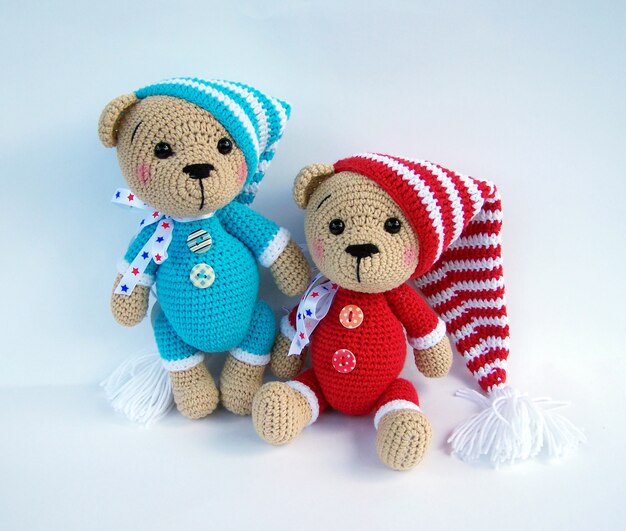 Cute handmade crochet bear doll isolated on white background with shadow reflection.