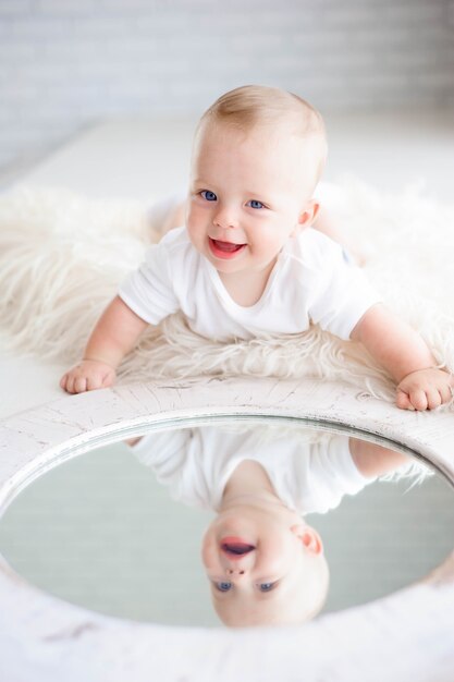 Cute happy 7 month baby girl in diaper lying and playing