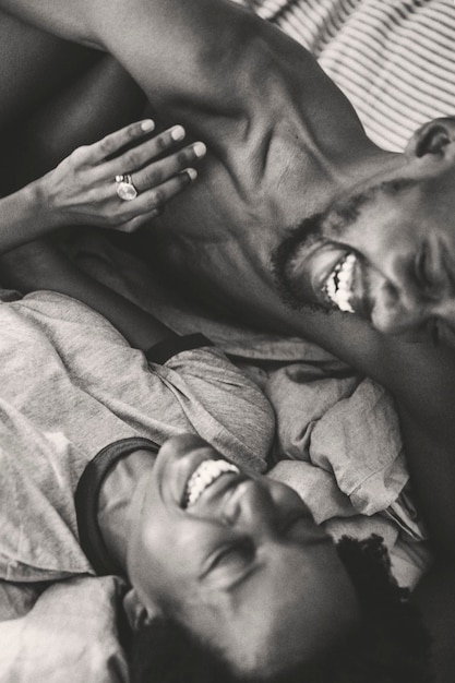 Cute happy black couple playing in bed