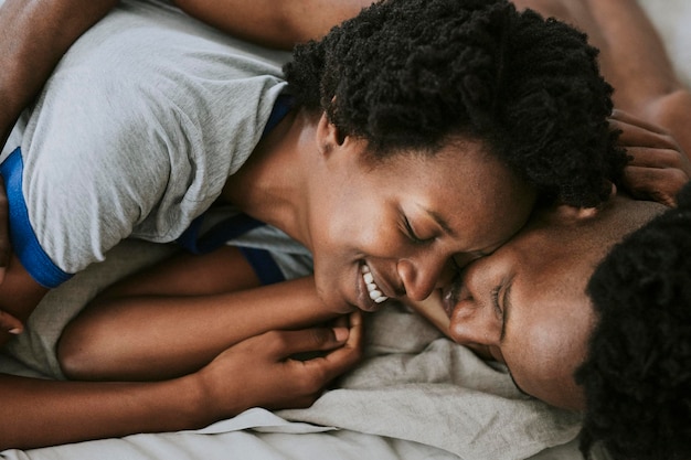 침대에서 노는 귀여운 행복한 흑인 커플