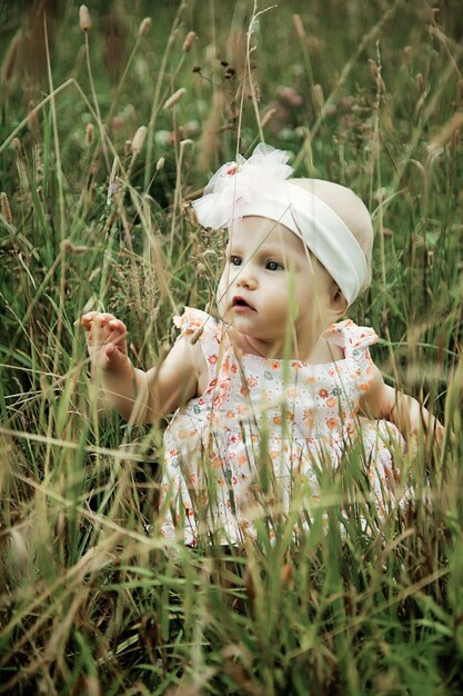 Photo cute happy blonde blue eyes girl 8 months old in grass