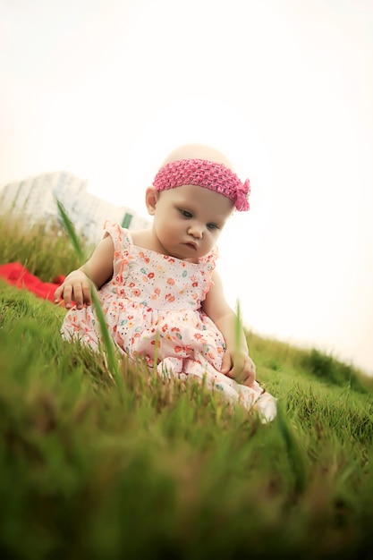 Cute happy blonde blue eyes girl 8 months old in grass