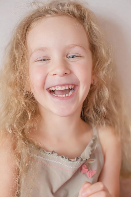 cute happy blonde girl with curly hair and blue eyes toothy smile