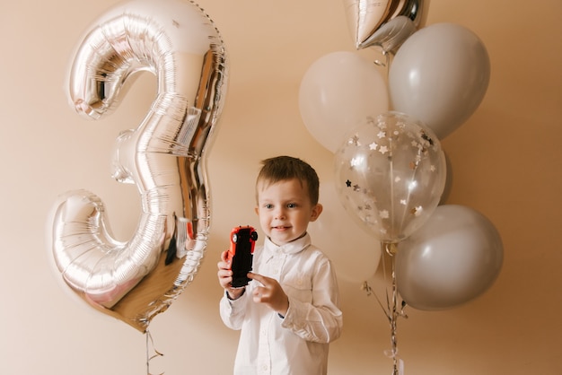 Cute happy boy at his birthday with balloons