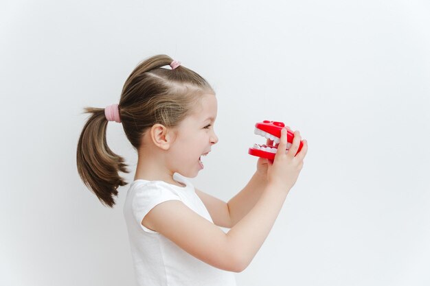 Photo cute happy caucasian toddler girl playing with dentist medical stomatology dental oral care