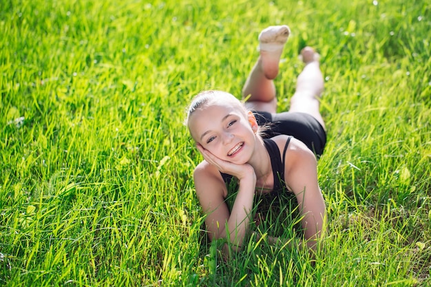 Cute happy little girl lying on the grass