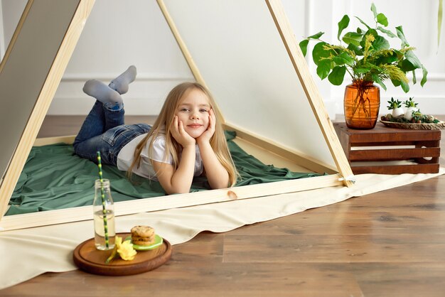 Cute happy little girl posing in a tent