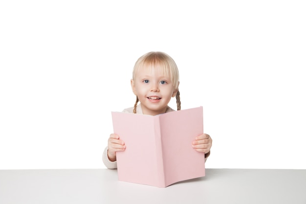 Cute happy little girl reading a book. Isolated on white background