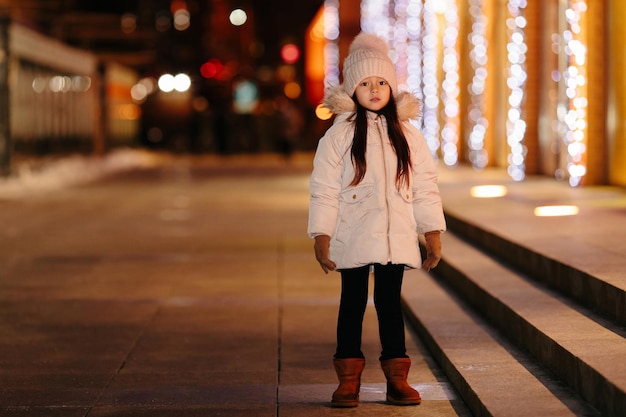 Cute happy little girl walks on the streets of a big city