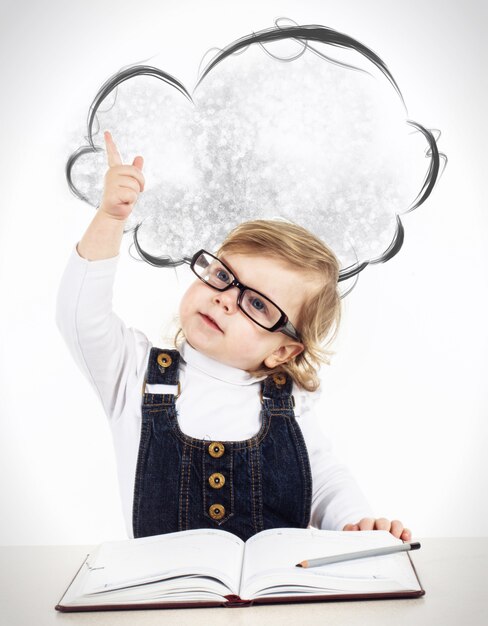 Foto scrittura felice sveglia della bambina qualcosa in taccuino