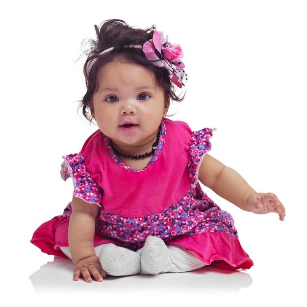 Photo cute happy and portrait of a baby girl sitting isolated on a white background in a studio girly playful and innocent adorable and small child smiling with happiness on a studio background