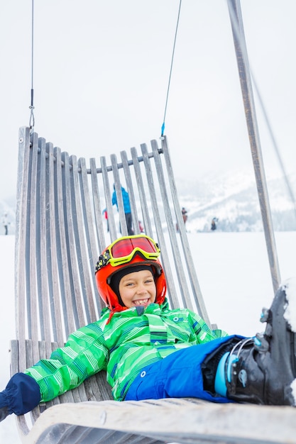 Cute happy skier boy in a winter ski resort.