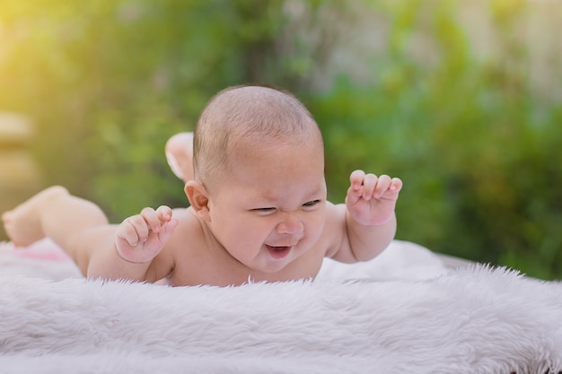 Cute happy smiling baby boy laying on white fur