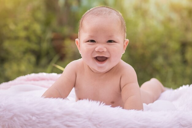 かわいい笑顔の赤ちゃんの男の子は、白い毛皮に