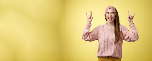 귀여운 헤비 메탈 애호가 로크 롤 상징을 보여주고 혀를 고 재미있고 행복한 농담을 하고 있습니다.