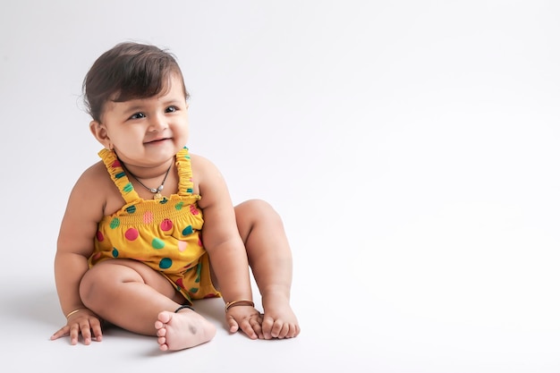 Симпатичная индийская девочка улыбается и выражает выражение