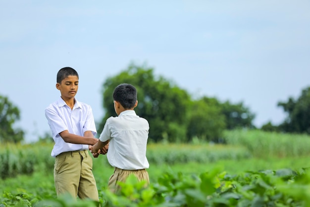 Милый индийский ребенок, играющий на зеленом поле