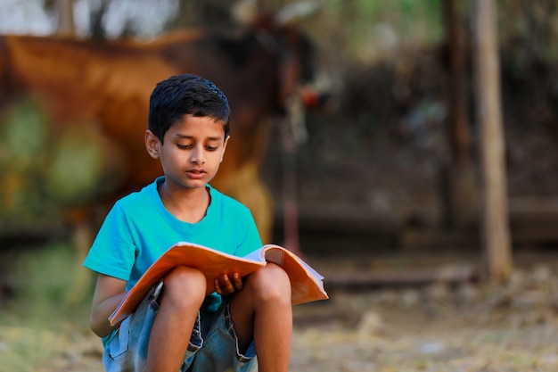 cute indian child reading his book