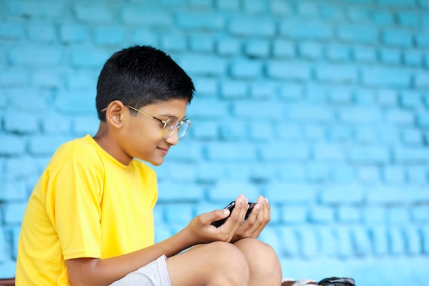 Cute Indian child using smartphone. online education concept