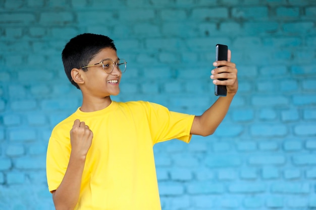 Cute Indian child using smartphone. online education concept