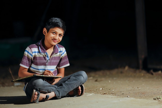 милый индийский ребенок, пишущий на грифельной доске