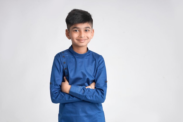 Cute indian little boy in ethnic wear and showing expression over white background