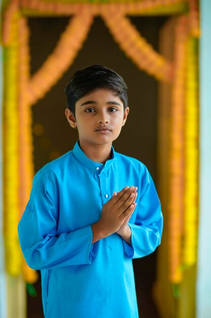 Cute indian little boy praying and celebrating diwali festival