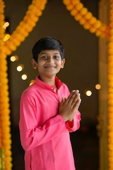 Simpatico ragazzino indiano che prega e celebra il festival di diwali.