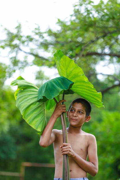 自然と一緒に楽しんでいるかわいいインドの小さな子供