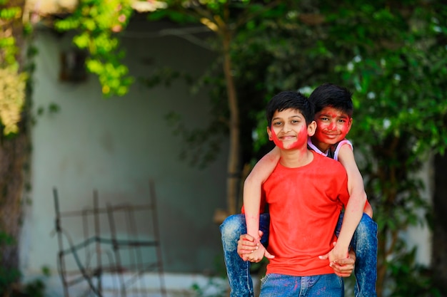 Bambini piccoli indiani svegli che giocano holi. holi è il festival dei colori in india