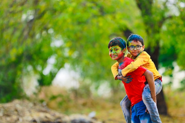 Bambini piccoli indiani svegli che giocano holi. holi è il festival dei colori in india