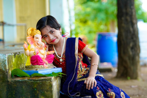 Bambina indiana sveglia che celebra il festival di lord ganesha