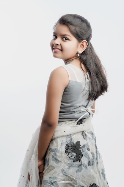 Cute indian little girl in ethnic wear and showing expression over white background