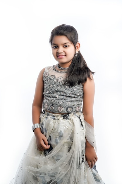 Cute indian little girl in ethnic wear and showing expression over white background