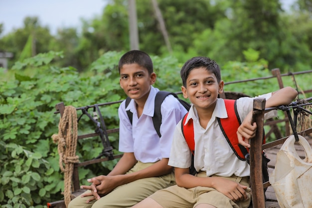 Cute indian schoolboys on a bullock cart