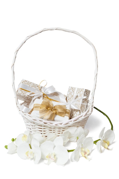 Cute isolated white and gold boxes with bows and ribbons in white basket with orchids branch