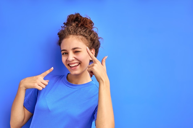 cute joydul cheerful girl have fun posing isolated in studio with blue background, attractive