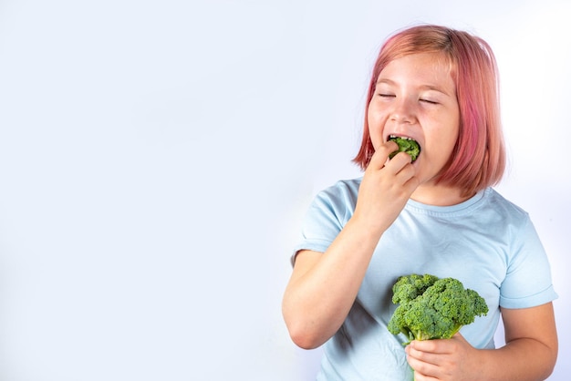 Cute kid girl eats broccoli